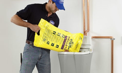 Процес засипання таблетованої солі в сольовий бак побутового пом'якшувача води